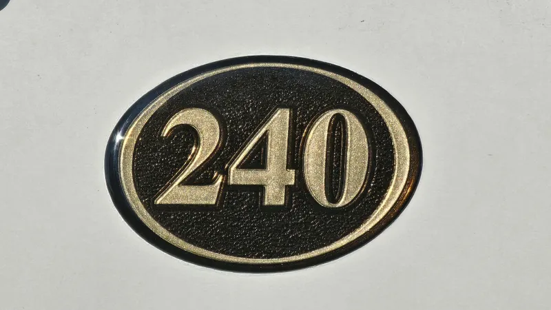 Slide: The Image of Reinell 240 C 2001 model emblem on white background. - 23
