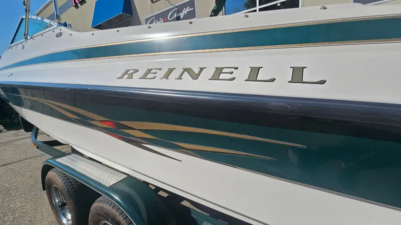 Slide: The Image of 2001 Reinell 240 C boat on trailer, featuring sleek design and vibrant graphics. - 24