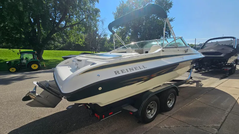 Slide: The Image of 2001 Reinell 240 C boat on trailer, parked outdoors, sunny day. - 4