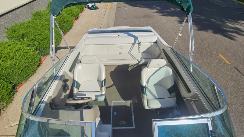Slide: The Image of 2001 Reinell 240 C boat interior with seating and steering wheel, parked on a street. - 6