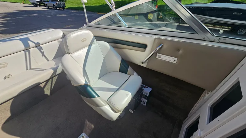 Slide: The Image of Interior of a 2001 Reinell 240 C boat, featuring a comfortable captain's chair. - 8