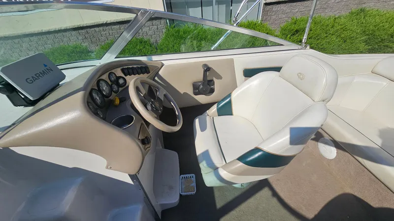 Slide: The Image of 2001 Reinell 240 C boat interior with steering wheel and Garmin device. - 9