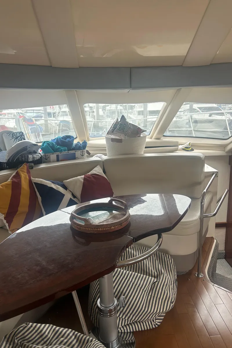 Slide: The Image of Interior of 2008 Sea Ray 47 Sedan Bridge with seating and table, docked at marina. - 18