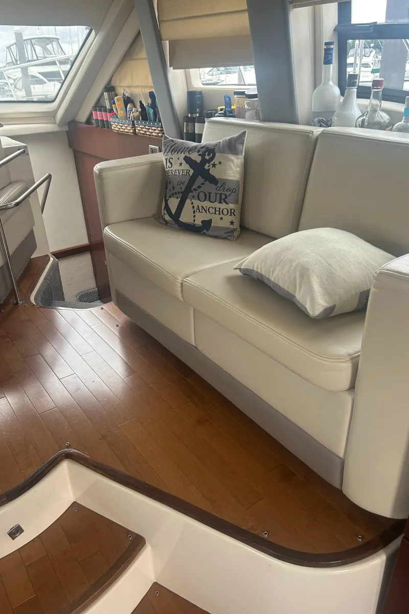 Slide: The Image of Interior of 2008 Sea Ray 47 Sedan Bridge with beige sofa and nautical decor. - 20