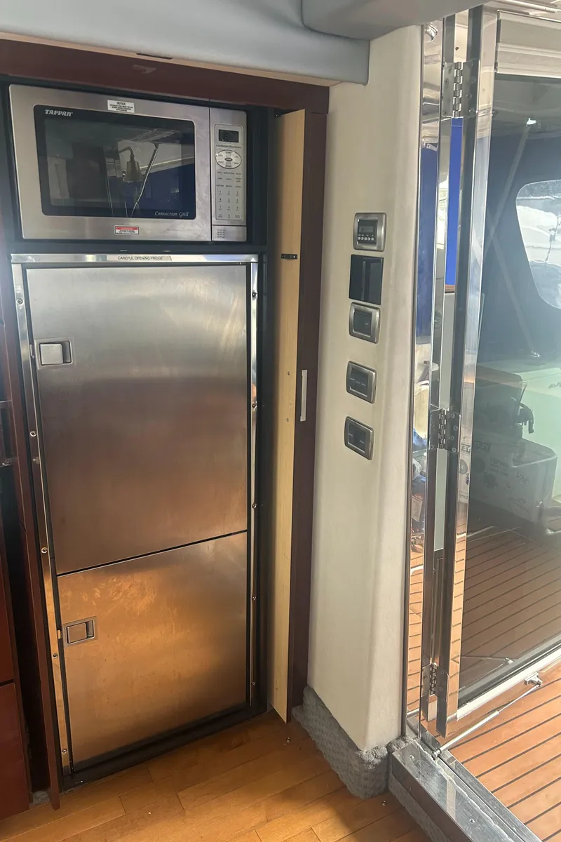 Slide: The Image of 2008 Sea Ray 47 Sedan Bridge yacht kitchen with stainless steel appliances and microwave. - 21