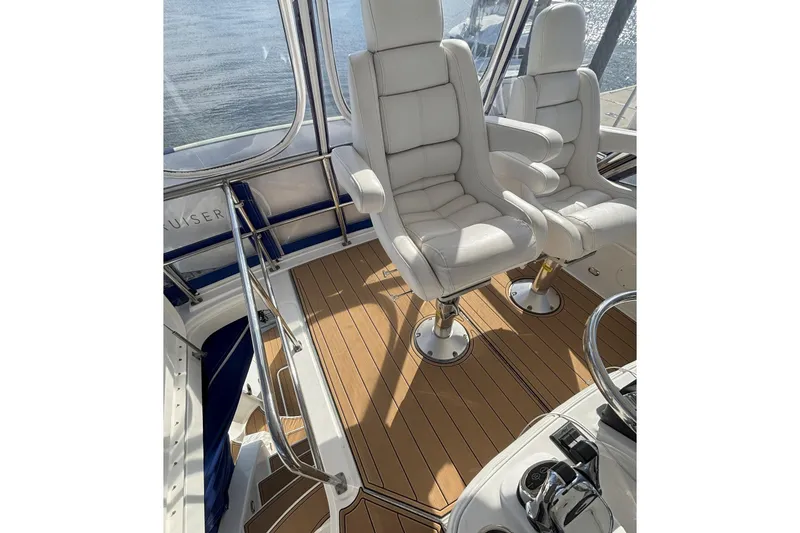 Slide: The Image of 2008 Sea Ray 47 Sedan Bridge helm with white captain chairs and teak flooring. - 26