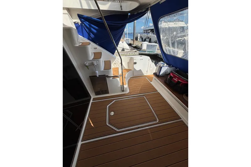 Slide: The Image of 2008 Sea Ray 47 Sedan Bridge yacht deck with wooden flooring and blue canopy. - 29