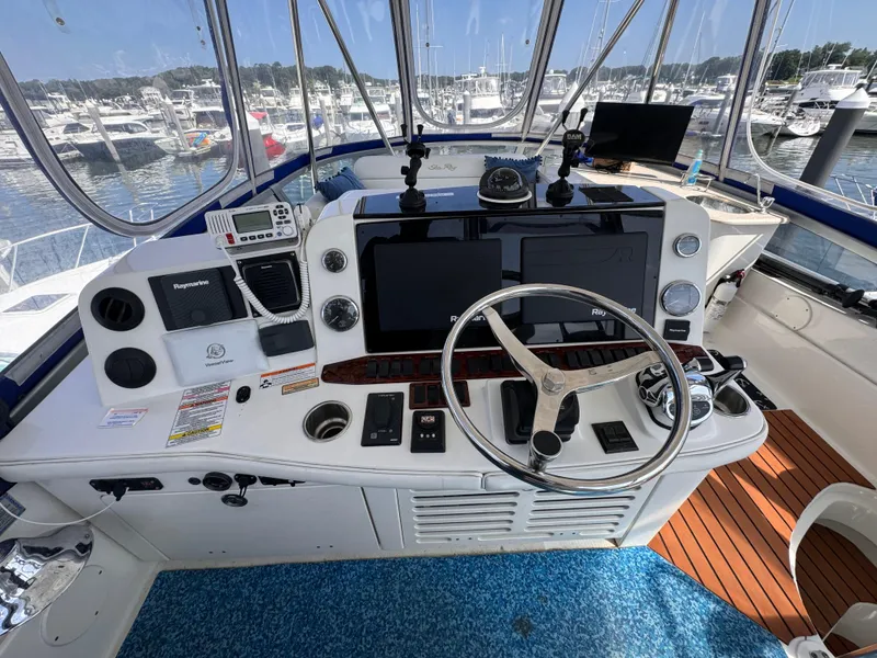Slide: The Image of 2008 Sea Ray 47 Sedan Bridge helm with modern navigation equipment and marina view. - 5