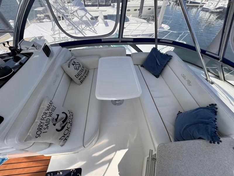 Slide: The Image of 2008 Sea Ray 47 Sedan Bridge interior with white seating and nautical-themed pillows. - 6