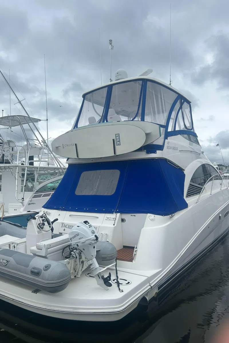 Slide: The Image of 2008 Sea Ray 47 Sedan Bridge yacht with blue canopy docked at marina. - 8