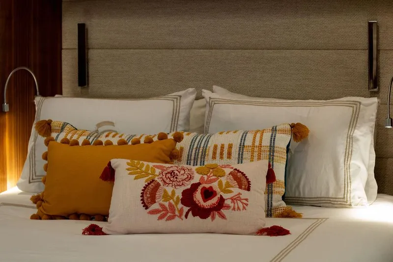 Slide: The Image of Luxurious Sirena 58 Flybridge 2022 bedroom with decorative pillows and elegant lighting. - 22