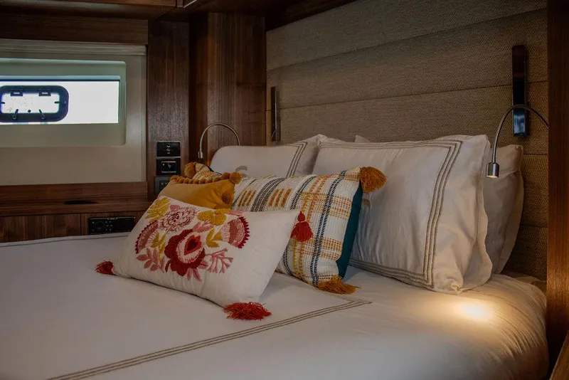 Slide: The Image of Luxurious bedroom interior of 2022 Sirena 58 Flybridge yacht with decorative pillows. - 24