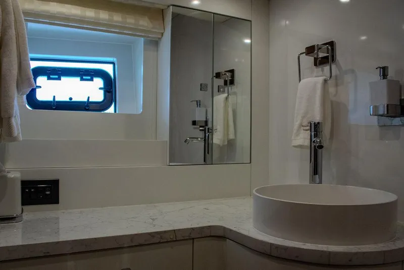 Slide: The Image of Luxurious bathroom in 2022 Sirena 58 Flybridge yacht with modern fixtures and porthole window. - 27