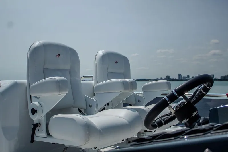 Slide: The Image of Luxury helm seats on 2022 Sirena 58 Flybridge yacht, overlooking serene waters. - 32