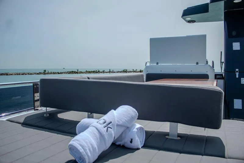 Slide: The Image of Sirena 58 Flybridge 2022 yacht deck with towels, ocean view in background. - 38