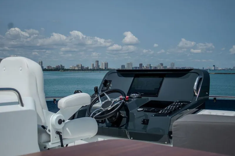 Slide: The Image of Sirena 58 Flybridge 2022 yacht helm with city skyline in background. - 39