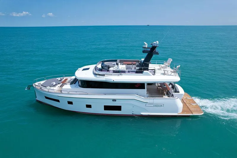 Slide: The Image of 2022 Sirena 58 Flybridge yacht cruising on clear blue ocean waters. - 7