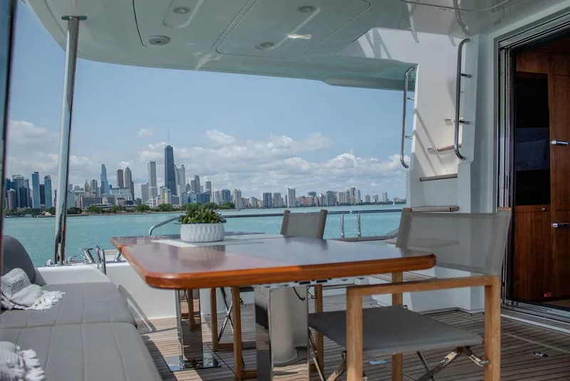 Slide: The Image of Sirena 58 Flybridge 2022 yacht with city skyline view, elegant outdoor seating area. - 8