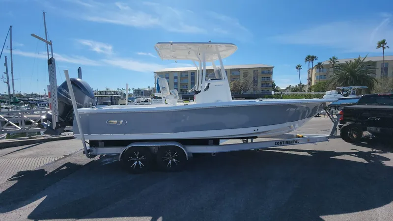 Slide: The Image of 2020 Sea Hunt BX 25 BR boat on trailer at marina under clear sky. - 15