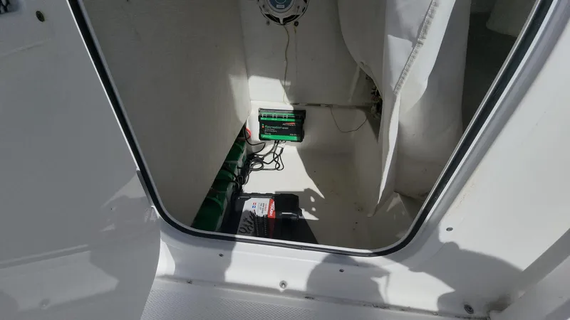 Slide: The Image of 2020 Sea Hunt BX 25 BR boat interior storage compartment with battery and wiring. - 36