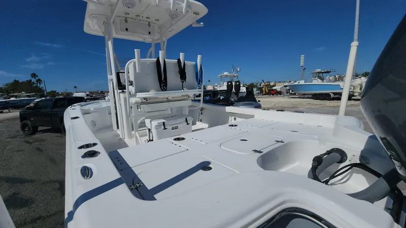 Slide: The Image of 2020 Sea Hunt BX 25 BR boat with spacious deck and seating, docked under clear blue sky. - 39