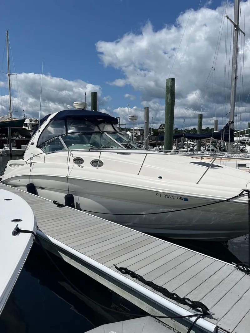 Slide: The Image of 2006 Sea Ray 320 Sundancer docked at marina under blue sky. - 2