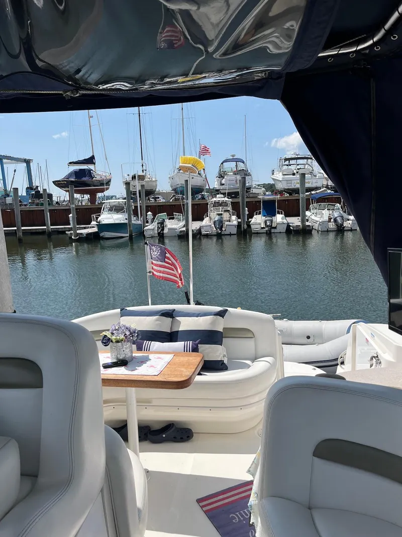 Slide: The Image of 2006 Sea Ray 320 Sundancer yacht docked at marina with American flag. - 4