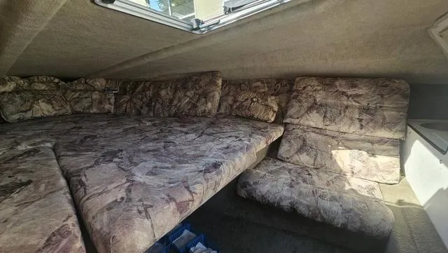 Slide: The Image of 2001 Reinell 240 C cabin interior with patterned upholstery and compact layout. - 13