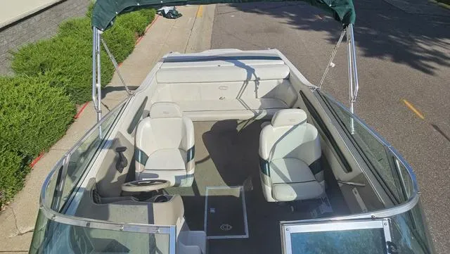 Slide: The Image of 2001 Reinell 240 C boat interior with seating and steering wheel, parked on a street. - 6