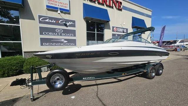 Slide: The Image of 2001 Reinell 240 C boat on trailer outside a marine dealership. - 2