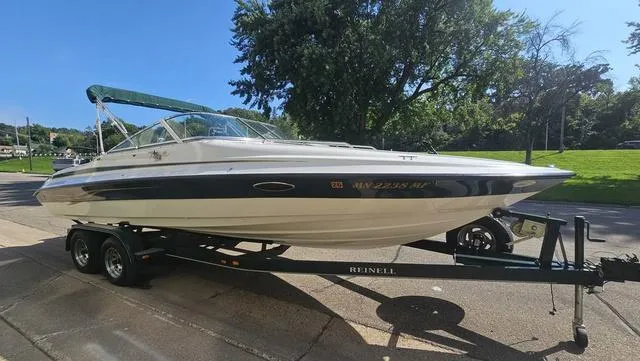Slide: The Image of 2001 Reinell 240 C boat on trailer, parked outdoors on a sunny day. - 3