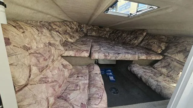 Slide: The Image of 2001 Reinell 240 C boat interior with patterned upholstery and overhead hatch. - 12