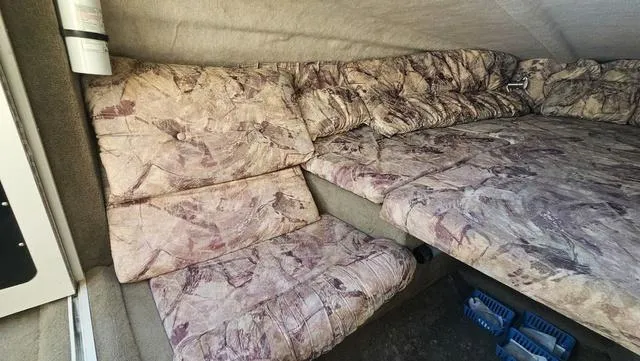 Slide: The Image of 2001 Reinell 240 C cabin interior with patterned upholstery and seating area. - 14