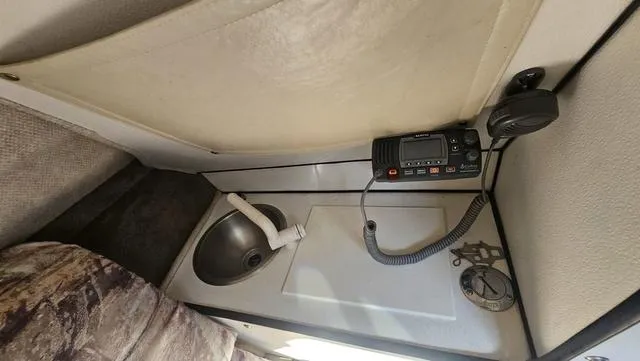 Slide: The Image of Interior of a 2001 Reinell 240 C boat featuring a sink and radio equipment. - 15
