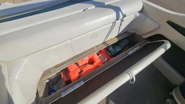 Slide: The Image of Storage compartment in a 2001 Reinell 240 C boat, containing life jackets and safety gear. - 17