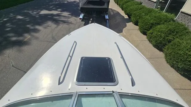 Slide: The Image of 2001 Reinell 240 C boat on trailer, viewed from above, parked near shrubs. - 18