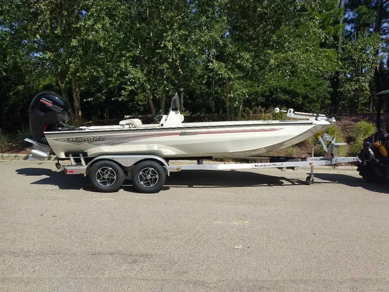 Slide: The Image of 2024 Ranger RB200 boat on trailer, parked outdoors with trees in the background. - 3