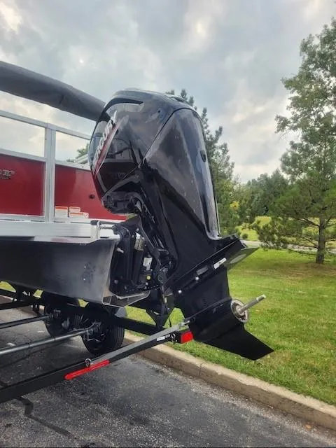Slide: The Image of 2024 Ranger Reata 200F boat with powerful outboard motor, parked on a trailer. - 2