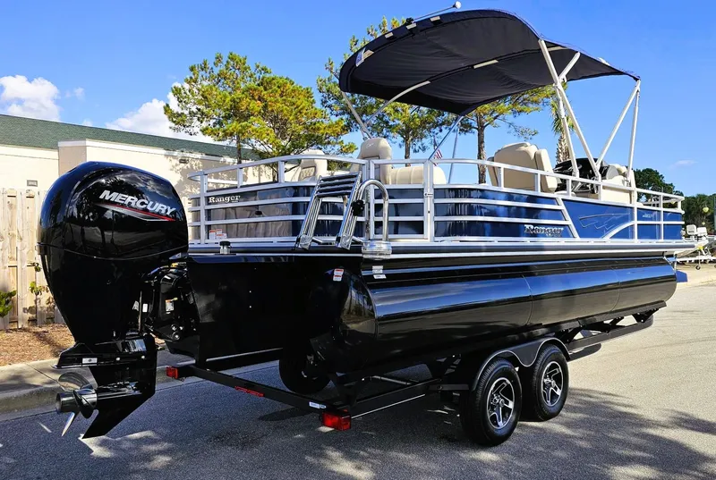 Slide: The Image of 2024 Ranger Reata 223F pontoon boat with Mercury engine, parked on a trailer. - 2