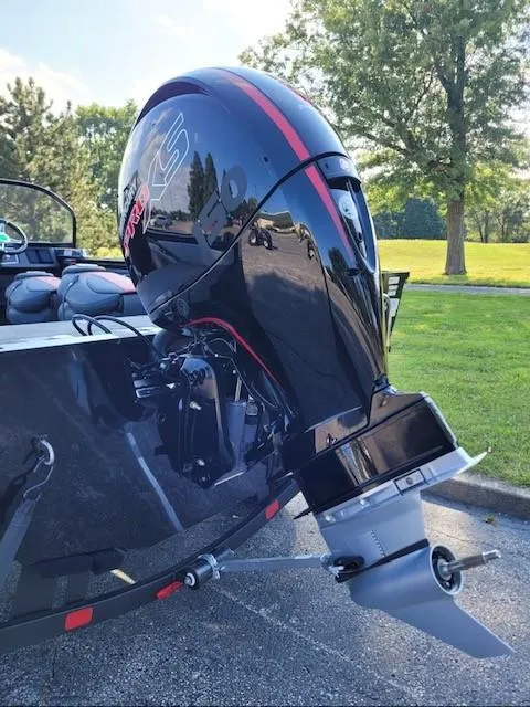 Slide: The Image of 2024 Ranger VX1788 WT boat with powerful outboard motor in a sunny park setting. - 2