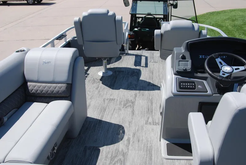 Slide: The Image of 2024 Ranger Reata 220F boat interior with gray seating and modern dashboard. - 13