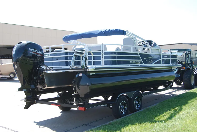 Slide: The Image of 2024 Ranger Reata 220F pontoon boat with Mercury outboard engine on a trailer. - 2