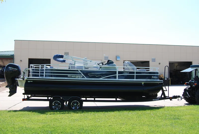 Slide: The Image of 2024 Ranger Reata 220F pontoon boat on trailer outside a building. - 3