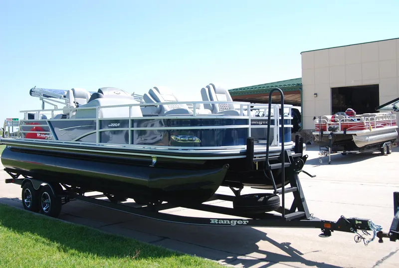 Slide: The Image of 2024 Ranger Reata 220F pontoon boat on trailer, parked outdoors. - 4