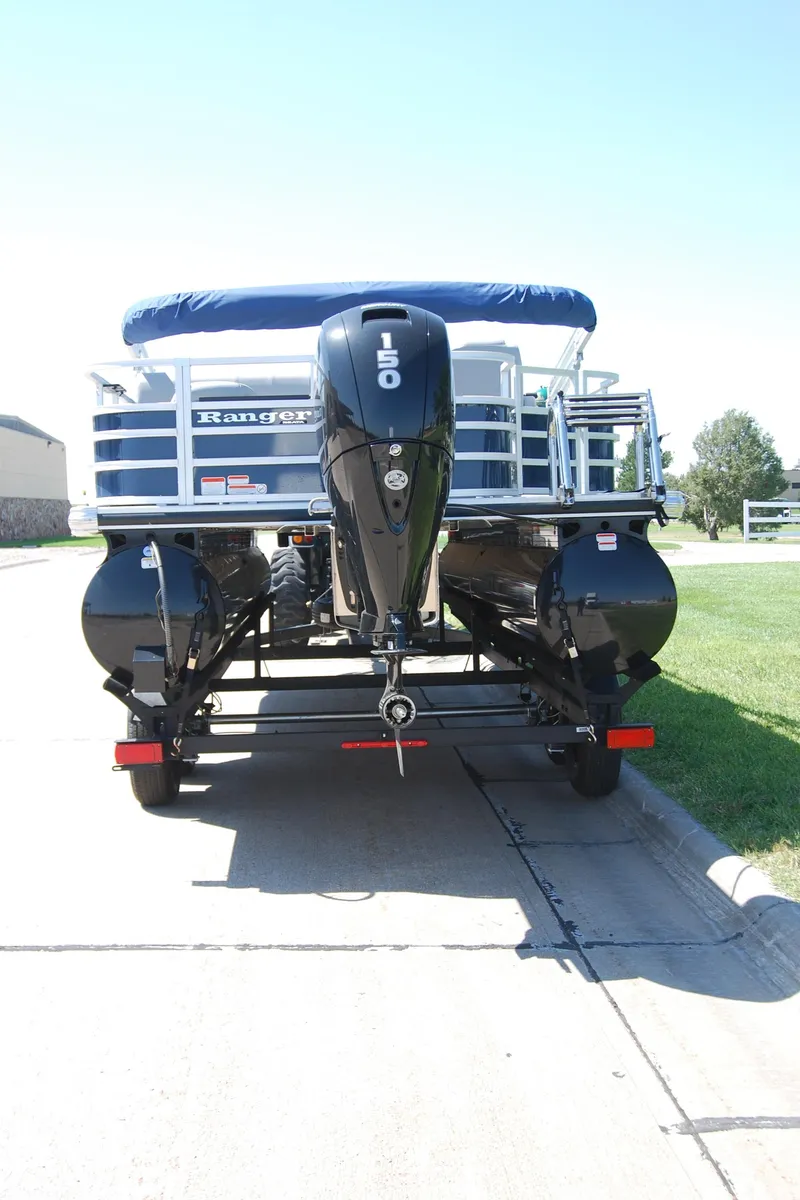 Slide: The Image of 2024 Ranger Reata 220F pontoon boat with powerful outboard motor, parked on a sunny day. - 5