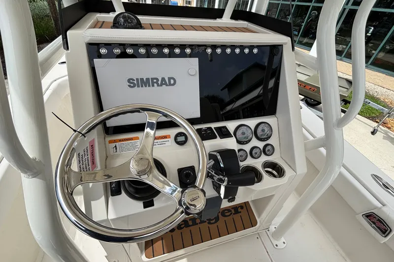 Slide: The Image of 2024 Ranger 2600 Bay boat dashboard with Simrad display and steering wheel. - 12