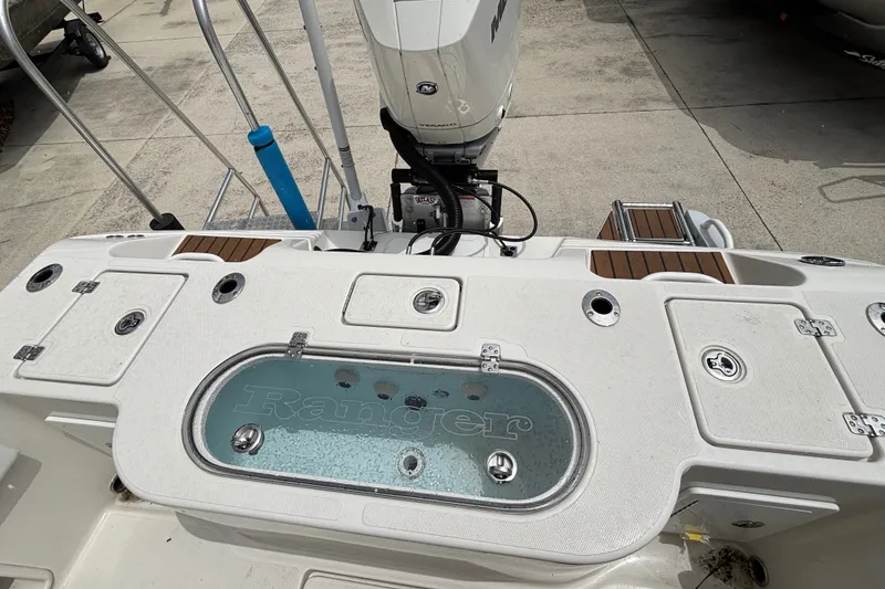 Slide: The Image of 2024 Ranger 2600 Bay boat deck with motor and storage compartments. - 13