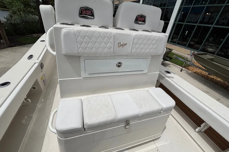 Slide: The Image of 2024 Ranger 2600 Bay boat interior with white cushioned seating and storage compartment. - 14