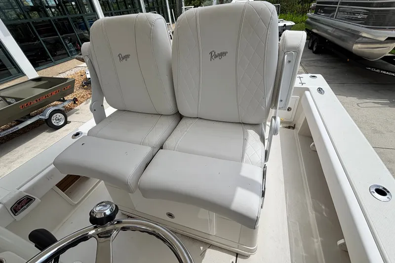 Slide: The Image of 2024 Ranger 2600 Bay boat with white cushioned seats and steering wheel. - 10