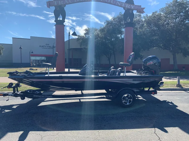 Slide: The Image of 2024 Ranger RT188 boat parked outdoors under a sunny sky. - 0